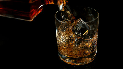 Detail of pouring whiskey into glass