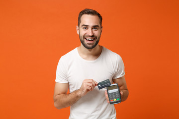 Smiling young man in white t-shirt posing isolated on orange background. People lifestyle concept....
