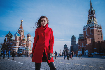 Happy women walking in red coat at the red square in Moscow