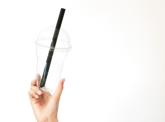 Holding a plastic cup with a plastic straw on a white background,stop the plastic straw and secure environment concept