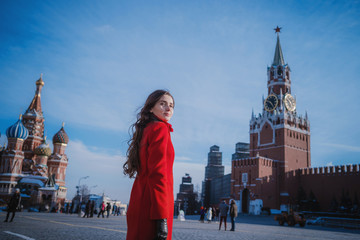 Happy women walking in red coat at the red square in Moscow