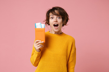 Shocked young brunette woman girl in yellow sweater posing isolated on pastel pink wall background...