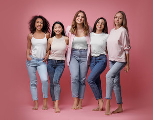 Group of women with different body types on pink background
