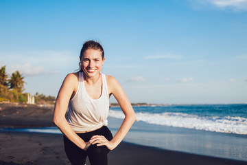 Healthy energetic woman stretching at seaside