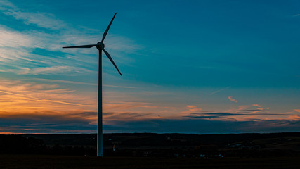 Beautiful sunset with wind power plant silhouette near Kugl, Bavaria, Germany