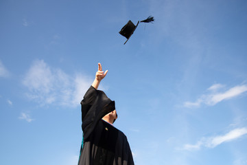 A graduate threw a hat up to sky of graduation ceremony in Graduation day. Success of educations concept. Forward future concept.