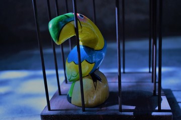 Wooden toy parrot in a cage