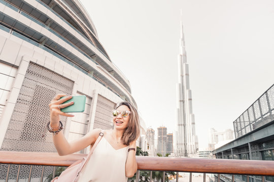 Happy girl traveler and blogger takes selfie photo in Dubai, United Arab Emirates