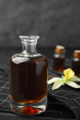 Obraz na płótnie Canvas Aromatic homemade vanilla extract in glass bottle on table, closeup