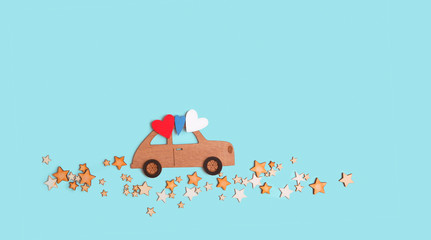 wooden toy car with hearts and stars road on blue background. greeting cad design, New Year, Christmas, father's day, Valentine's day holidays concept. copy space. template for design