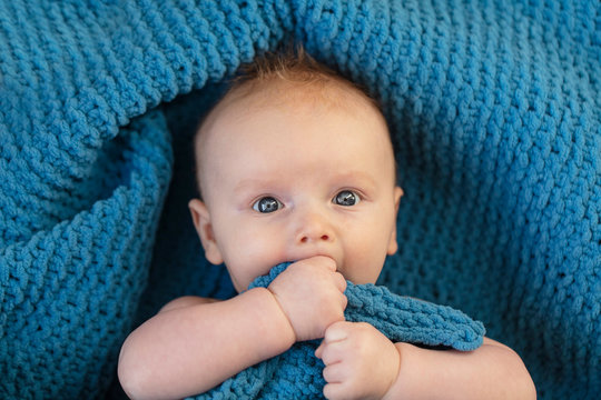 A Cute Baby Boy Hugging A Soft Blue Blanket