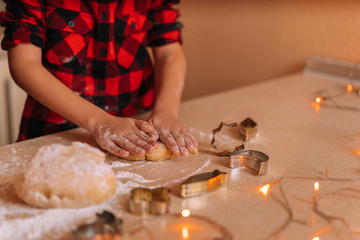 Hand of a little boy making traditional christmas cookies.