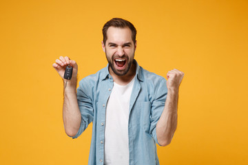 Happy young man in casual blue shirt posing isolated on yellow orange background, studio portrait....