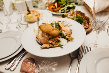 Served banquet table in a restaurant with cold, hot appetizers. Sliced meat, bread in bowls on the table. Feast on a a birthday party, a party, a business reception. Delicacies, delicious meals.