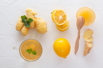 Tea with ginger, mint, lemon and honey on a white wooden table. Top view