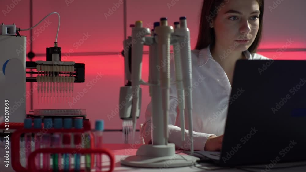 Wall mural Young woman use Automated DNA Processor real-time PCR cycler.  PCR robotic machine for molecular and genetic research laboratory