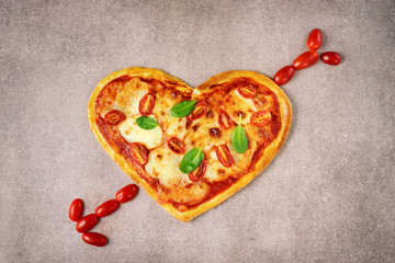 Delicious heart shaped Italian pizza on brown background