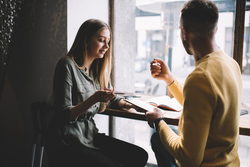 Attentive coworkers reading papers in eatery
