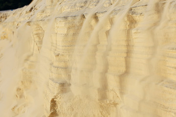 the texture of the sand is drowned by sand dunes / sand avalanche is showered off the dune, an unusual texture of sand