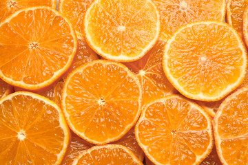 Slices of fresh ripe tangerines as background, top view. Citrus fruit