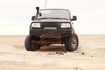 Fototapeta na wymiar SUV in the desert / old vintage all-terrain vehicle, expedition in the desert on the sand, extreme cars
