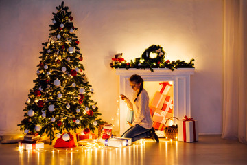 beautiful woman decorates the Christmas tree Garland lights new year holiday