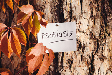 Psoriasis or eczema - symptom of skin sickness, medical lettering on paper on nature backgroud 
