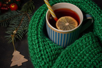 New year Christmas background. It is a bowl filled with a red drink wrapped in a warm scarf. Lying Christmas decorations. The concept of winter, solitude, Christmas, warmth and comfort.