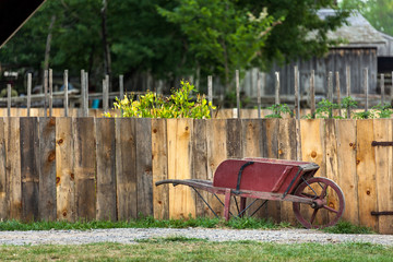 Old vintage red wheelbarrow in yard.