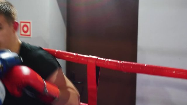 Boxing - a man in black t-shirt having a fight in the corner of the ring