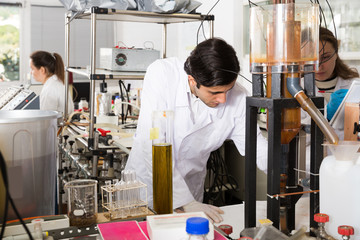 Positive man chemist working in laboratory