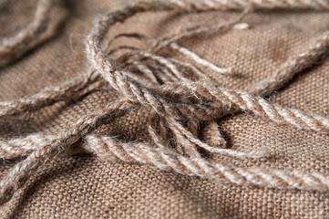 twine and burlap on a black wooden background, still life