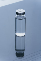 Glass medical ampoule vial for injection. Medicine is dry white drug penicillin powder or liquid with of aqueous solution in ampulla. Close up. Bottles ampule with aluminum cap on backgrounds gray.