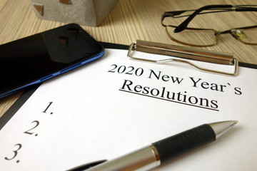 2020 New Year resolutions text with accessories on office desk