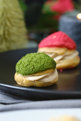 christmas choux cream or cream puff or French profiteroles with fresh cream set on cafe table.