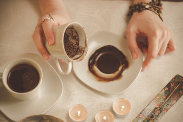 Coffee ground fortune teller, holding cup of coffee, close up