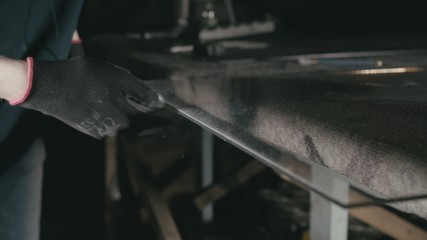Forge. Smithy. Glass cutting and processing for fireplace doors. Circular glass cutter. Worker cut...