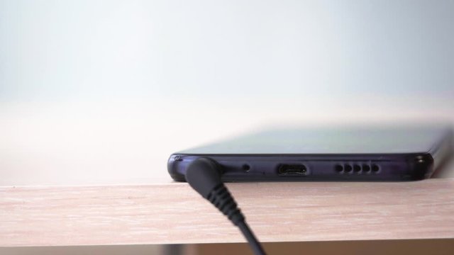 Insert and pull out the plug of the audio jack smartphone. Connecting headphones to smart phone. Extreme closeup of headphone mini jack plug.