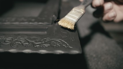 Forge workshop. Smithy manual production. The product is artificially aged. Gold powder painting of scratches, roughness and scuffs. Ageing. Aging processes. Pattern on iron. Carving ornament.