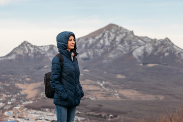 young woman with backpack on mountain top on mountain background