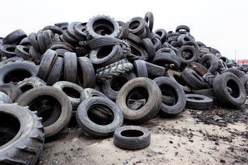 Industrial landfill for the processing of waste tires and rubber tyres. Pile of old tires and wheels for rubber recycling. Tyre dump