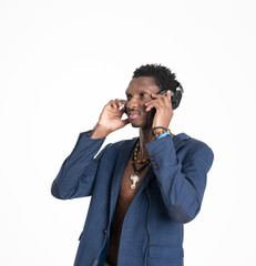 A black guy (man) in a blue jacket and jeans is listening music with headphones