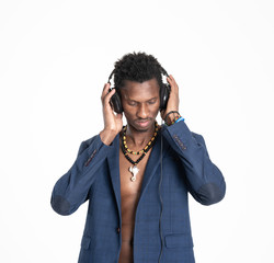 A black guy (man) in a blue jacket and jeans is listening music with headphones