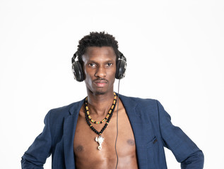 A black guy (man) in a blue jacket and jeans is listening music with headphones