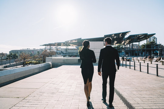 Elegant business people in sunny city
Back view of elegant professional businessman and woman in suits walking together on street against futuristic buildings in back lit
