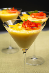 Vanilla Pudding with lemon and strawberry garnish in Martini glass with black background.