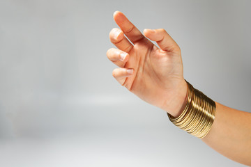 Gold bangles by women hand. Traditional gold bangles stacked