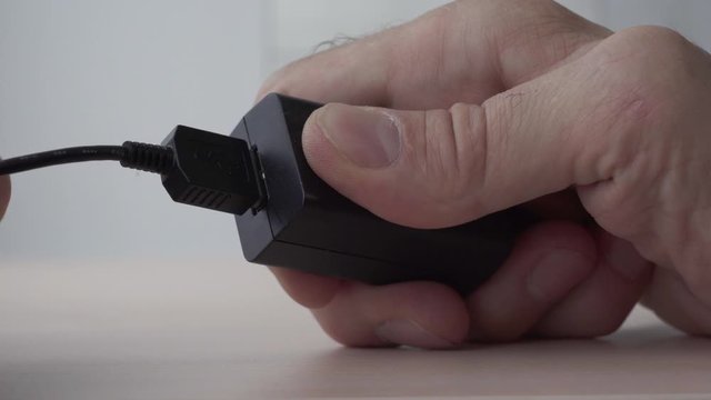 Usb cable being plugged in small usb wall charger.