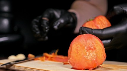 The cook makes salsa. Salsa for burgers on hot Mexican hot recipes. It is prepared from a tomato, red chili peppers, onions, white onions. All chalks are cut with a knife.