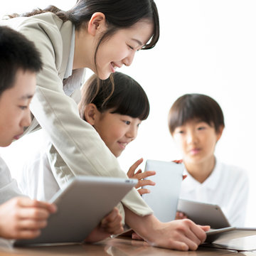 先生にプログラミングの勉強を教わる小学生  AR